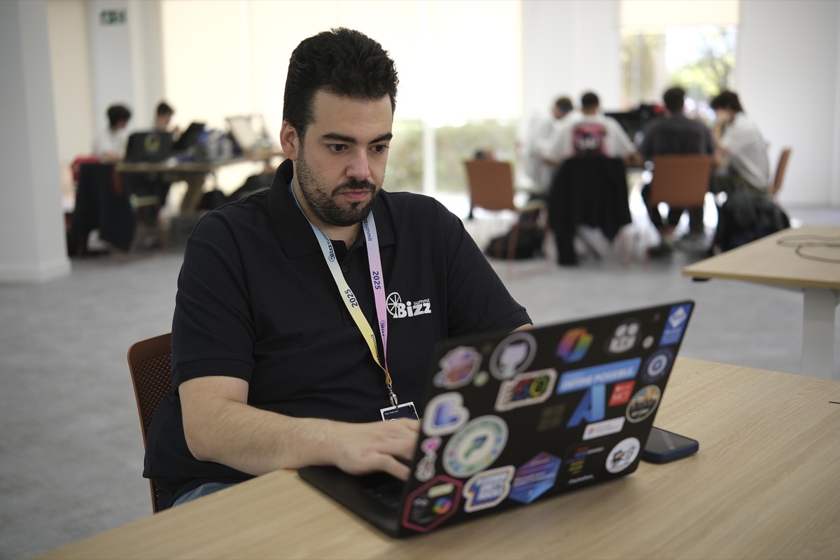 Alex working on a laptop at the Bizz Summit conference.