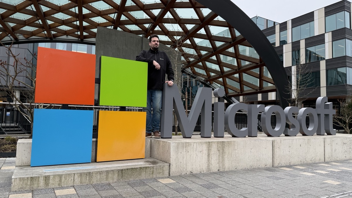 Alex at the Microsoft campus with a giant Microsoft logo.